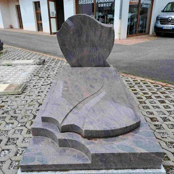 Monument funéraire en granit gris et rose aux lignes ondulées modernes