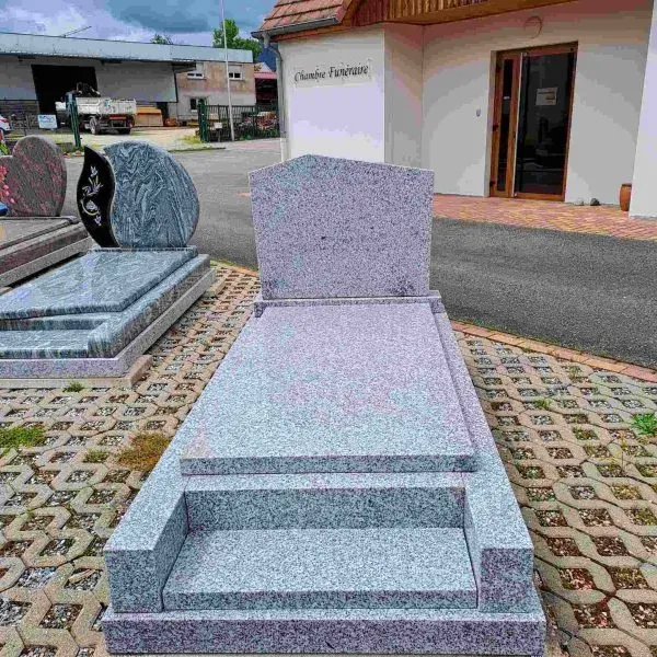 Monument funéraire classique en granit gris clair avec marchepied et stèle droite