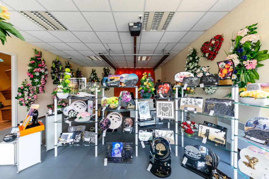 Intérieur de la boutique funéraire présentant des plaques de souvenir et compositions florales